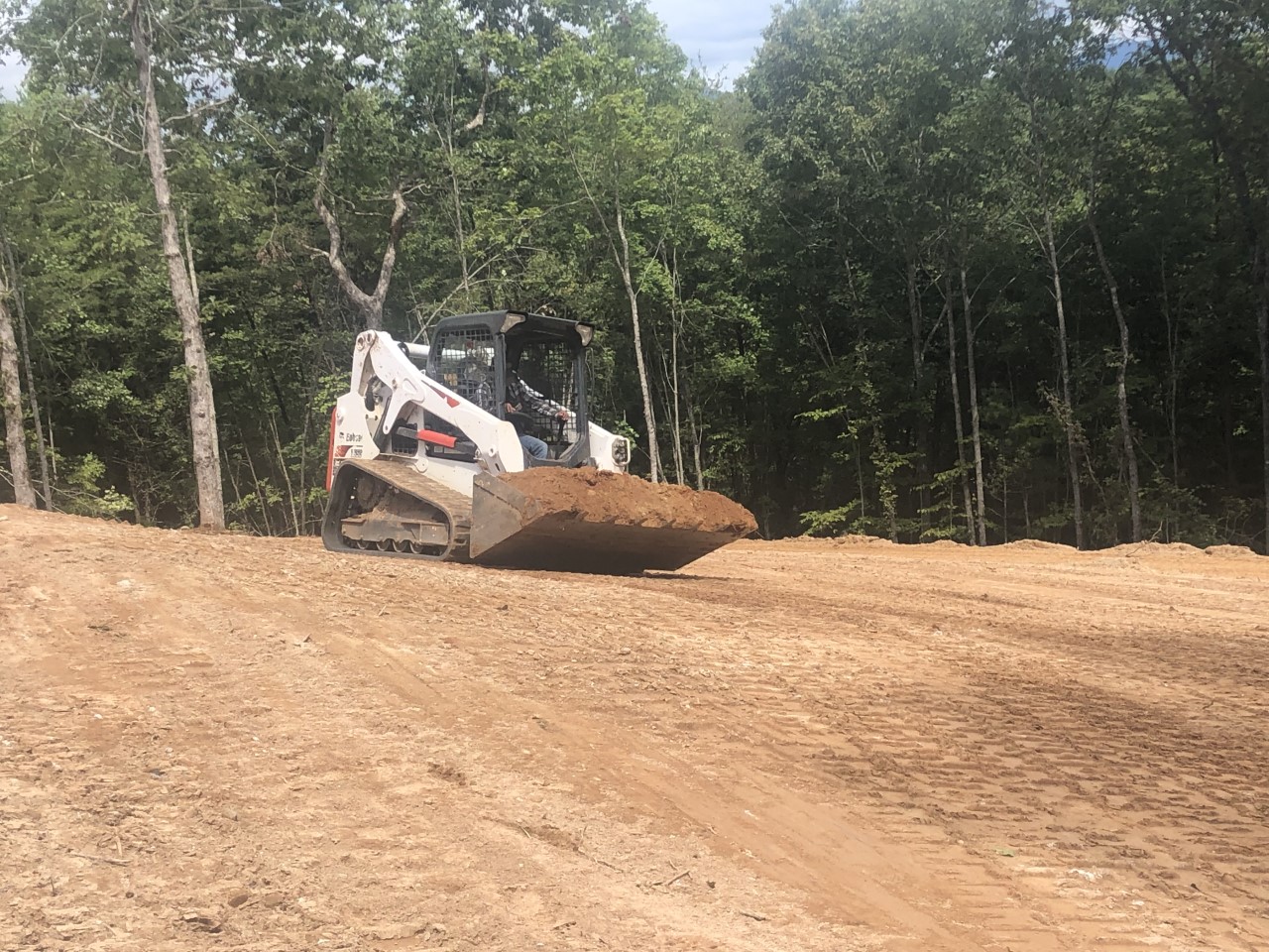 A Bobcat skid steer loader that is used to grade